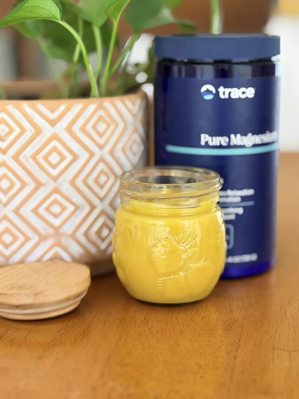 A glass jar of creamy homemade magnesium balm with shea butter and beeswax, in warm natural light